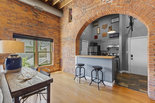 51 W Blenkner St Unit 306, Columbus, OH 43215 - dining space with a high ceiling, arched walkways, and wood finished floors