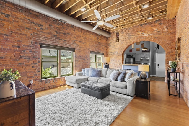 51 W Blenkner St Unit 306, Columbus, OH 43215 - living area with a ceiling fan, brick wall, wood finished floors, and arched walkways