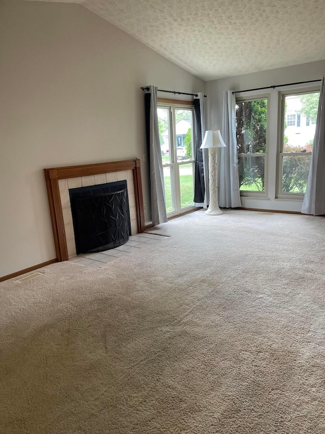 7581 Toweron Ln, Columbus, OH 43235 - unfurnished living room with lofted ceiling, a textured ceiling, carpet flooring, and a tile fireplace