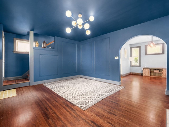211 E Jenkins Ave, Columbus, OH 43207 - unfurnished dining area with arched walkways, wood finished floors, and a chandelier