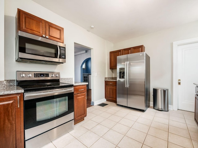 211 E Jenkins Ave, Columbus, OH 43207 - kitchen featuring appliances with stainless steel finishes, brown cabinetry, and light stone counters