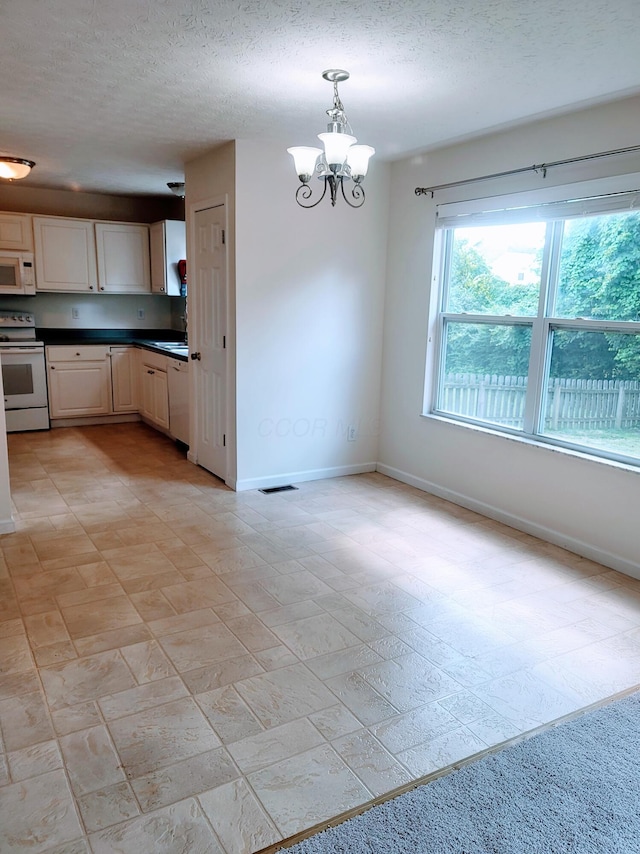 417 Hannifin Dr, Blacklick, OH 43004 - kitchen with white appliances, a chandelier, dark countertops, a textured ceiling, and pendant lighting