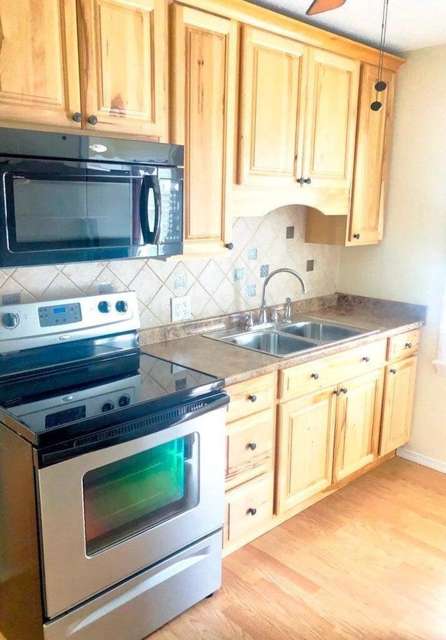 2580 Audubon Rd, Columbus, OH 43211 - kitchen with electric range, black microwave, light wood-style floors, backsplash, and light brown cabinetry