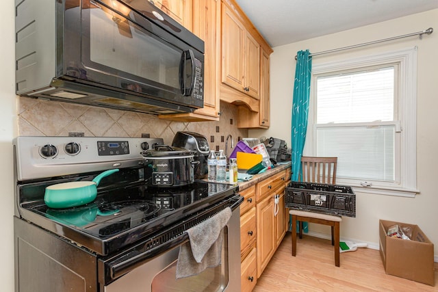 2580 Audubon Rd, Columbus, OH 43211 - kitchen featuring electric stove, black microwave, decorative backsplash, light wood finished floors, and light brown cabinets