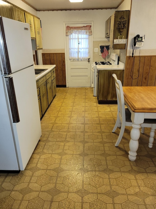 327 Ziegler Ave, Columbus, OH 43207 - kitchen with white appliances, light countertops, a wainscoted wall, and light flooring
