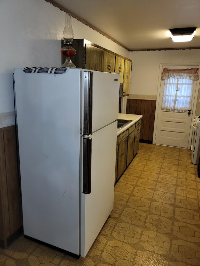 327 Ziegler Ave, Columbus, OH 43207 - kitchen with freestanding refrigerator, light countertops, light flooring, and a wainscoted wall