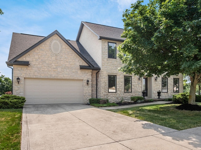 7635 Overland Trl, Delaware, OH 43015 - french country style house featuring stone siding, a shingled roof, concrete driveway, and an attached garage