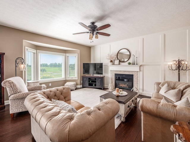 7635 Overland Trl, Delaware, OH 43015 - living area featuring a ceiling fan, dark wood-type flooring, a textured ceiling, a tile fireplace, and a chandelier
