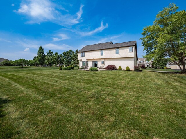 7635 Overland Trl, Delaware, OH 43015 - rear view of property with stucco siding and a lawn