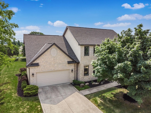 7635 Overland Trl, Delaware, OH 43015 - view of front of home with stone siding, roof with shingles, a garage, a front lawn, and driveway