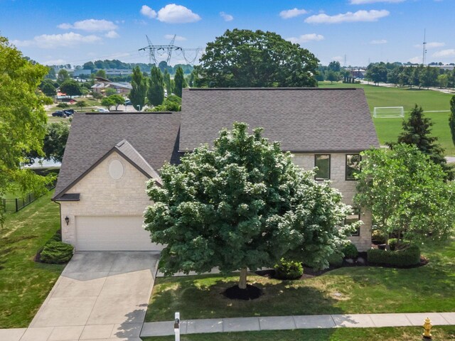 7635 Overland Trl, Delaware, OH 43015 - view of front of home featuring a shingled roof, driveway, a garage, and a front yard