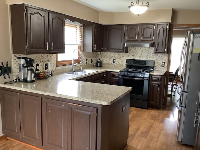 374 Chatham Rd, Circleville, OH 43113 - kitchen featuring stainless steel appliances, a peninsula, light countertops, under cabinet range hood, and backsplash