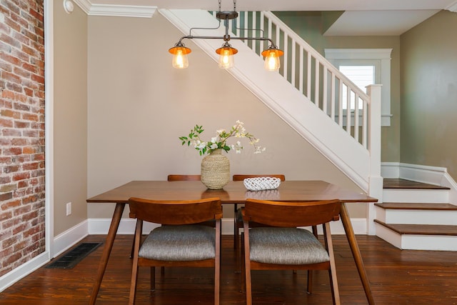489 Elsmere St, Columbus, OH 43206 - dining room featuring stairs, wood-type flooring, and brick wall
