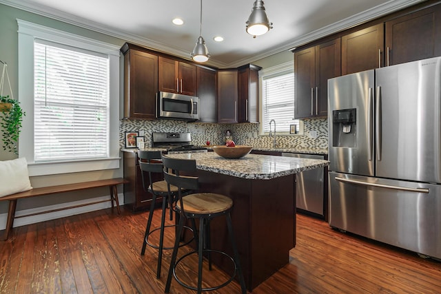 489 Elsmere St, Columbus, OH 43206 - kitchen with stainless steel appliances, dark brown cabinets, crown molding, dark wood-type flooring, and a kitchen island