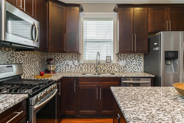 489 Elsmere St, Columbus, OH 43206 - kitchen featuring stainless steel appliances, light stone counters, backsplash, and dark brown cabinets