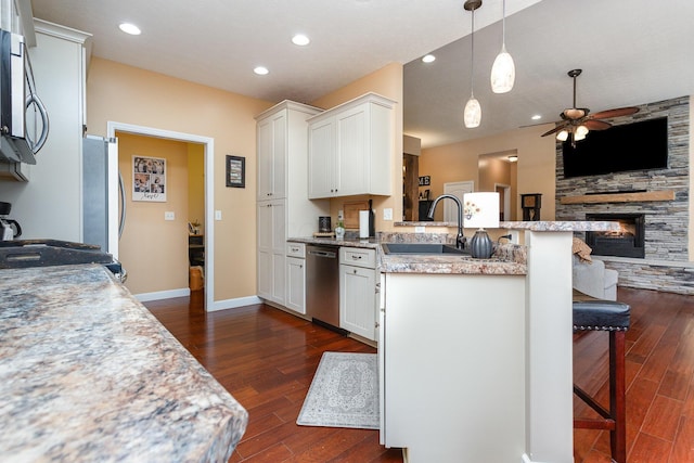 5582 Hayesville Rd, Circleville, OH 43113 - kitchen featuring appliances with stainless steel finishes, a peninsula, a ceiling fan, a breakfast bar, and dark wood-type flooring