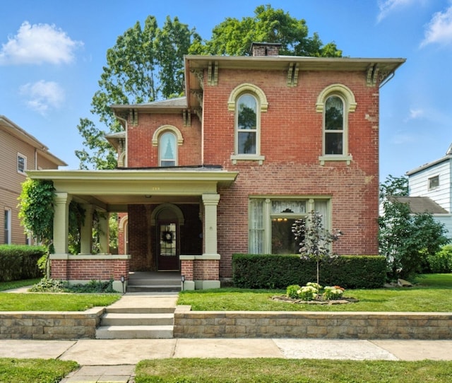 249 W Locust St, Newark, OH 43055 - italianate home with brick siding, a front yard, a porch, and a chimney