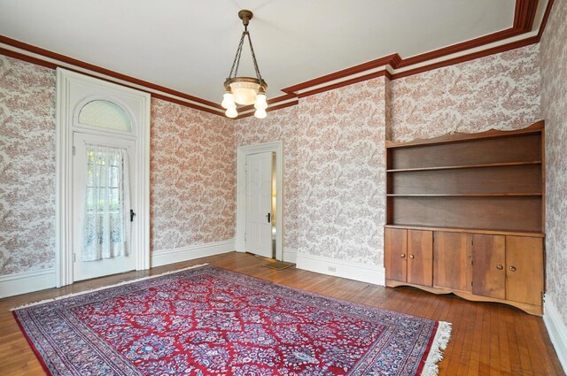 249 W Locust St, Newark, OH 43055 - unfurnished dining area featuring wood-type flooring, ornamental molding, and wallpapered walls