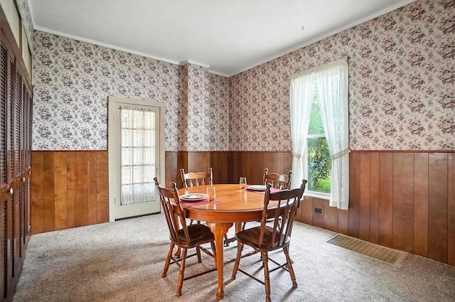 249 W Locust St, Newark, OH 43055 - dining space with healthy amount of natural light, wainscoting, ornamental molding, wood walls, and carpet