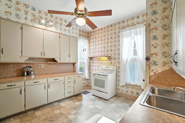 249 W Locust St, Newark, OH 43055 - kitchen featuring electric range, wallpapered walls, a ceiling fan, light countertops, and cream cabinets