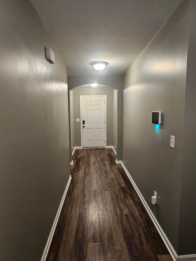 7520 Autumn Joy Ave, Canal Winchester, OH 43110 - corridor featuring dark wood-style flooring, arched walkways, and a textured ceiling