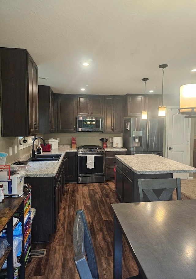 7520 Autumn Joy Ave, Canal Winchester, OH 43110 - kitchen with appliances with stainless steel finishes, dark wood-style floors, recessed lighting, decorative light fixtures, and a center island