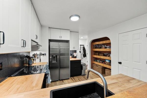 5813 Camhurst Ct, Galloway, OH 43119 - kitchen with stainless steel fridge with ice dispenser, under cabinet range hood, butcher block countertops, and white cabinets