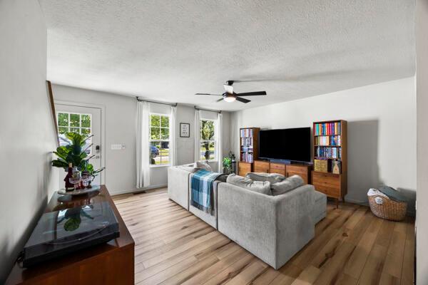 5813 Camhurst Ct, Galloway, OH 43119 - living room featuring a textured ceiling, light wood-style flooring, and a ceiling fan