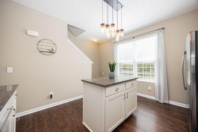 5738 Hayden Run Blvd, Dublin, OH 43016 - kitchen with freestanding refrigerator, dark wood-type flooring, white cabinets, dark stone countertops, and a textured ceiling