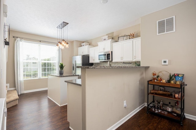 5738 Hayden Run Blvd, Dublin, OH 43016 - kitchen featuring stainless steel appliances, dark wood-style flooring, white cabinets, a peninsula, and a textured ceiling