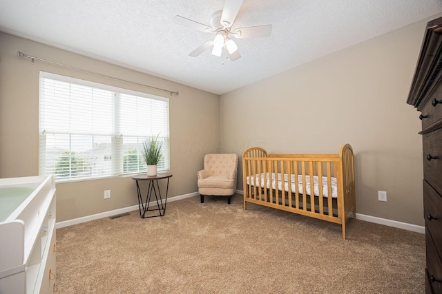 5738 Hayden Run Blvd, Dublin, OH 43016 - bedroom with light colored carpet, a crib, a textured ceiling, and ceiling fan