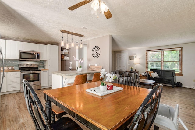 2630 Bella Via Ave, Columbus, OH 43231 - dining room featuring light wood-type flooring, ceiling fan, and a textured ceiling