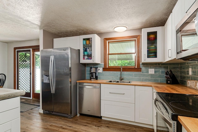2630 Bella Via Ave, Columbus, OH 43231 - kitchen with butcher block countertops, appliances with stainless steel finishes, healthy amount of natural light, decorative backsplash, and a textured ceiling