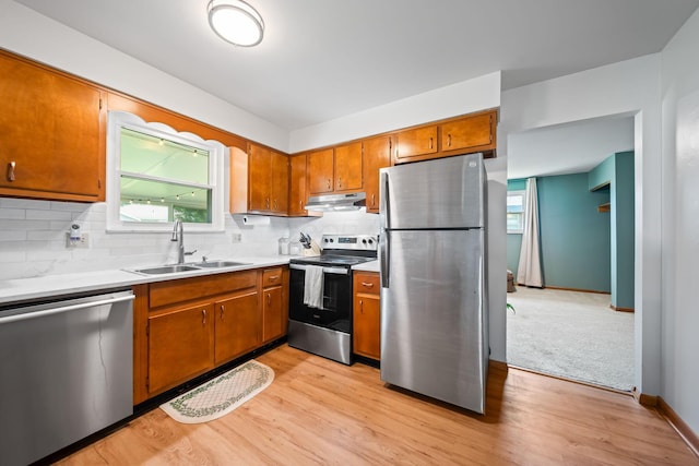 4868 Almont Dr, Columbus, OH 43229 - kitchen featuring stainless steel appliances, under cabinet range hood, light wood-style flooring, and brown cabinetry