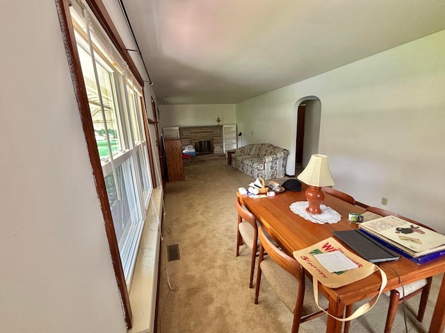 298 N Vernon Ave, Newark, OH 43055 - dining area featuring light carpet, a fireplace with raised hearth, and arched walkways