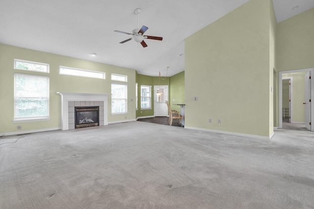 8078 Slate Ridge Blvd, Reynoldsburg, OH 43068 - unfurnished living room with high vaulted ceiling, a ceiling fan, a tile fireplace, plenty of natural light, and carpet floors