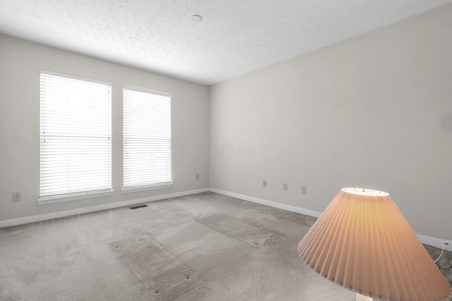 8078 Slate Ridge Blvd, Reynoldsburg, OH 43068 - empty room featuring plenty of natural light, a textured ceiling, and carpet flooring