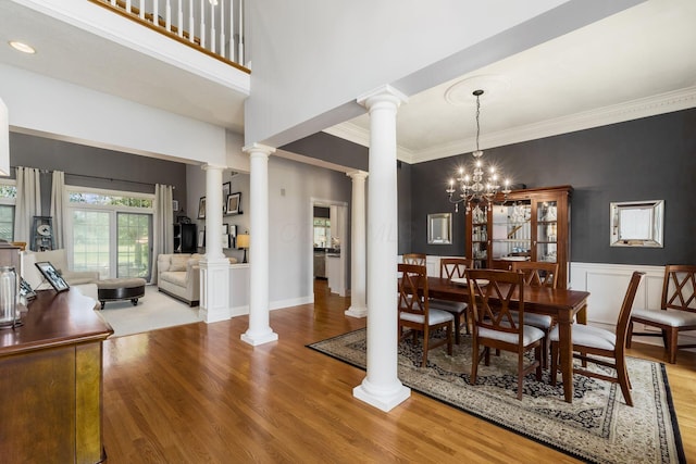 3873 Carters Corner Rd, Sunbury, OH 43074 - dining area featuring ornate columns, wood finished floors, ornamental molding, a chandelier, and wainscoting