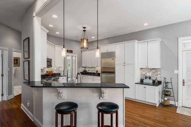 3873 Carters Corner Rd, Sunbury, OH 43074 - kitchen featuring appliances with stainless steel finishes, a peninsula, dark wood finished floors, dark countertops, and recessed lighting