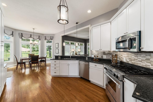 3873 Carters Corner Rd, Sunbury, OH 43074 - kitchen with stainless steel appliances, white cabinetry, a peninsula, decorative backsplash, and recessed lighting
