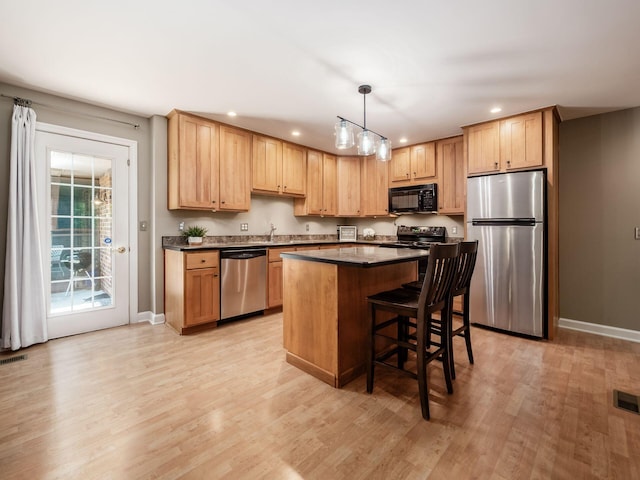 4656 Crompton Dr, Columbus, OH 43220 - kitchen with black appliances, recessed lighting, a kitchen island, dark countertops, and light wood-type flooring