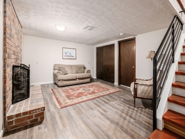 4656 Crompton Dr, Columbus, OH 43220 - living room featuring stairway, wood finished floors, a textured ceiling, and a fireplace