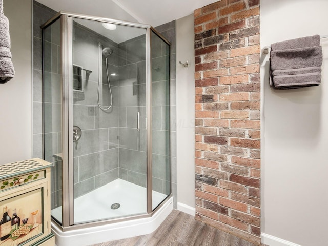 4656 Crompton Dr, Columbus, OH 43220 - bathroom featuring wood finished floors, a stall shower, and brick wall