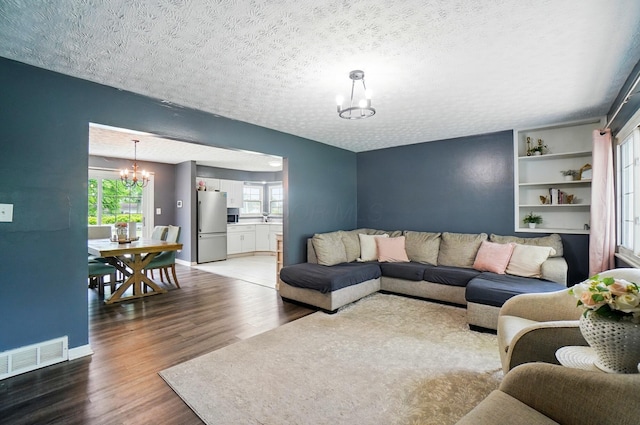3722 Florian Dr, Columbus, OH 43219 - living area featuring a chandelier, wood finished floors, and a textured ceiling