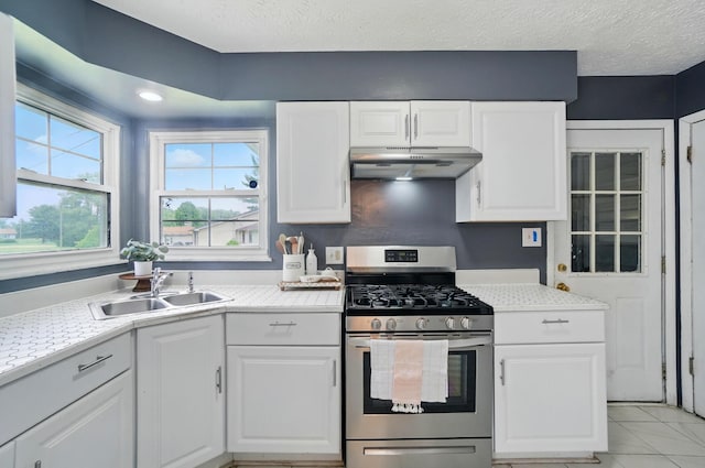 3722 Florian Dr, Columbus, OH 43219 - kitchen with stainless steel gas range oven, under cabinet range hood, light countertops, white cabinetry, and a textured ceiling