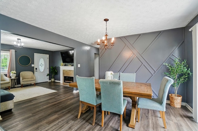 3722 Florian Dr, Columbus, OH 43219 - dining room featuring a decorative wall, a chandelier, a textured ceiling, wood finished floors, and a fireplace with flush hearth