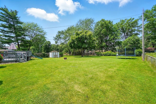 3722 Florian Dr, Columbus, OH 43219 - fenced backyard featuring a trampoline, a playground, a storage unit, and view of scattered trees