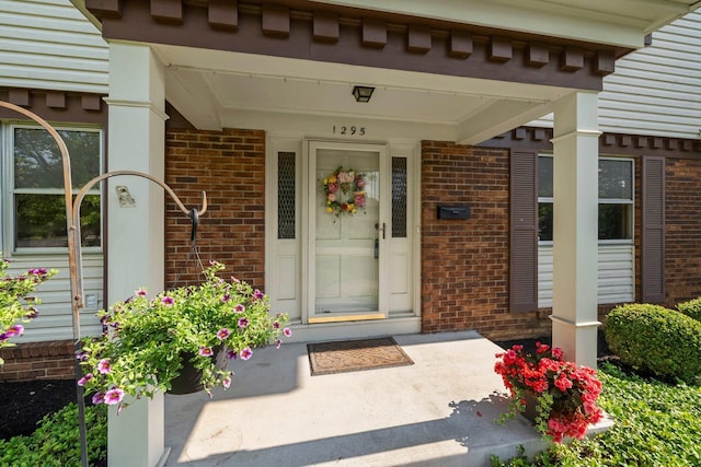 1295 Castleton Rd N, Columbus, OH 43220 - doorway to property featuring brick siding and covered porch