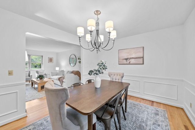 1295 Castleton Rd N, Columbus, OH 43220 - dining room featuring a chandelier, a wainscoted wall, light wood-style floors, and a decorative wall