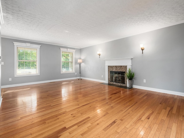 304 Cottage Grove Cir, Pataskala, OH 43062 - unfurnished living room with a textured ceiling, ornamental molding, light wood-type flooring, and a premium fireplace